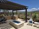 Outdoor patio area with pergola, built-in grill, fire pit, and comfortable seating for entertaining at 41809 N La Crosse Trl, Anthem, AZ 85086