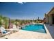 Inviting pool with water features, adjacent spa, desert landscaping, and patio furniture for relaxation and outdoor living at 41809 N La Crosse Trl, Anthem, AZ 85086