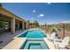 Backyard oasis featuring a sparkling pool, spa, covered patio, and desert views for relaxation and entertaining at 41809 N La Crosse Trl, Anthem, AZ 85086