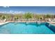 A desert landscaped pool with waterfall features, a hot tub, and desert views at 41809 N La Crosse Trl, Anthem, AZ 85086