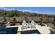 Relaxing poolside seating with desert landscaping and picturesque mountain views in the background at 41809 N La Crosse Trl, Anthem, AZ 85086