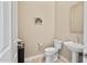 Bright powder room featuring pedestal sink, decorative mirror, and tiled floor at 41809 N La Crosse Trl, Anthem, AZ 85086