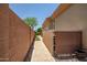 Side yard with paver pathway, privacy wall, and desert landscaping leading to home's exterior features at 41809 N La Crosse Trl, Anthem, AZ 85086