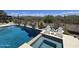 Luxury pool with spa surrounded by a patio, lush landscaping, desert views, and comfortable seating at 41809 N La Crosse Trl, Anthem, AZ 85086
