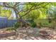 Picturesque backyard with lush landscaping, shade tree, brickwork, and firepit at 445 W 1St St, Mesa, AZ 85202