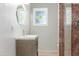 Bathroom vanity with sink and oval mirror adjacent to frameless glass shower at 445 W 1St St, Mesa, AZ 85202