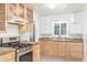 Traditional kitchen with wood cabinets, tiled countertops, and stainless steel appliances at 445 W 1St St, Mesa, AZ 85202
