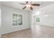 Empty living room with ceiling fan, bright windows, neutral walls, tile floor and natural light at 445 W 1St St, Mesa, AZ 85202