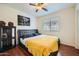 Comfortable bedroom featuring wood-look flooring, a ceiling fan, and a stylish upholstered headboard at 45311 W Woody Rd, Maricopa, AZ 85139