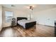 Large main bedroom with dark wood floors, a tufted headboard, and a wine fridge at 45311 W Woody Rd, Maricopa, AZ 85139