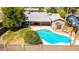Aerial view of a backyard featuring a sparkling pool, covered patio, and lush greenery at 5127 E Tamblo Dr, Phoenix, AZ 85044