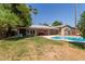 Inviting backyard with sparkling pool, covered patio, and lush green lawn at 5127 E Tamblo Dr, Phoenix, AZ 85044