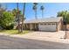 Charming single-story home with a well-manicured lawn, palm trees, and a two-car garage at 5127 E Tamblo Dr, Phoenix, AZ 85044