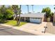 Beautiful home featuring a manicured lawn, mature trees, and a two-car garage at 5127 E Tamblo Dr, Phoenix, AZ 85044