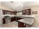 Well-lit kitchen featuring stainless steel appliances, dark wood cabinetry and light countertops at 5127 E Tamblo Dr, Phoenix, AZ 85044
