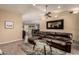 Living area showcasing a leather sectional, glass table, ceiling fan, and an open floor plan at 5127 E Tamblo Dr, Phoenix, AZ 85044