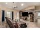 Inviting living room featuring a wood accent wall, ceiling fan, and a comfortable leather sofa at 5127 E Tamblo Dr, Phoenix, AZ 85044