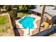 Aerial view of a backyard featuring a sparkling pool, covered patio, and lush greenery at 5127 E Tamblo Dr, Phoenix, AZ 85044