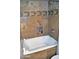 Close up of a tiled bathtub with jets and shower head at 5345 E Van Buren St # 115, Phoenix, AZ 85008