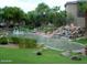 Beautiful community pond with a fountain, waterfall, and lush greenery, offering a serene and inviting outdoor space at 5345 E Van Buren St # 115, Phoenix, AZ 85008