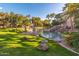 Scenic community pond featuring a waterfall, lush landscaping, and mature palm trees offering a serene outdoor escape at 5345 E Van Buren St # 115, Phoenix, AZ 85008