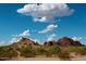 Scenic desert landscape with rocky mountains and native vegetation under a bright blue sky with fluffy clouds at 5345 E Van Buren St # 115, Phoenix, AZ 85008