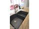 Close up of the granite kitchen sink with modern hardware and tile flooring at 5345 E Van Buren St # 115, Phoenix, AZ 85008