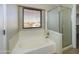 Bathroom featuring a soaking tub with a window and a glass-enclosed shower stall at 8022 S 48Th Dr Dr, Laveen, AZ 85339
