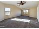Spacious bedroom with neutral carpet, a ceiling fan, and two large windows at 8022 S 48Th Dr Dr, Laveen, AZ 85339