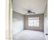 Neutral bedroom features a ceiling fan, window, and neutral carpet at 836 N Sinova Ave, Gilbert, AZ 85234