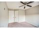This neutral bedroom features a ceiling fan and closet with white doors at 836 N Sinova Ave, Gilbert, AZ 85234