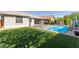 Backyard oasis featuring a sparkling pool, artificial turf, and covered patio at 8828 N 102Nd Ln, Peoria, AZ 85345