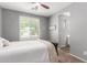 Bright bedroom with a ceiling fan, plantation shutters and view into the en-suite bathroom at 8828 N 102Nd Ln, Peoria, AZ 85345
