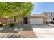Charming single-story home showcasing a well-manicured front yard and a two-car garage at 8828 N 102Nd Ln, Peoria, AZ 85345
