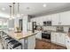 Bright, open kitchen features white cabinets, stainless appliances and granite counters with island seating at 8828 N 102Nd Ln, Peoria, AZ 85345