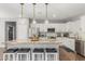 Spacious kitchen featuring a large granite island with bar stool seating, white cabinetry and stainless appliances at 8828 N 102Nd Ln, Peoria, AZ 85345