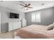 Spacious main bedroom with ceiling fan, adjacent ensuite bathroom, and shuttered windows at 8828 N 102Nd Ln, Peoria, AZ 85345