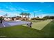 Beautiful backyard with sports court, putting green, mature landscaping, and palm trees at 9148 N 66Th Pl, Paradise Valley, AZ 85253