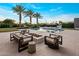 Inviting backyard oasis with a pool, fire pit, outdoor seating and palm trees against a clear blue sky at 9148 N 66Th Pl, Paradise Valley, AZ 85253