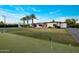 Expansive backyard with large lawn, mature landscaping, and a putting green at 9148 N 66Th Pl, Paradise Valley, AZ 85253