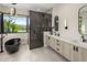 Modern bathroom showcasing a sleek black soaking tub, spacious vanity, and glass enclosed shower at 9148 N 66Th Pl, Paradise Valley, AZ 85253
