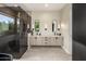A stylish bathroom featuring a large floating vanity, mirrors, decorative light fixtures, and glass shower at 9148 N 66Th Pl, Paradise Valley, AZ 85253