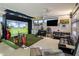 Entertaining indoor golf simulator space with seating, golf equipment, and tv for relaxing at 9148 N 66Th Pl, Paradise Valley, AZ 85253