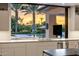 Kitchen overlooking pool, palm trees and vibrant sunset at 9148 N 66Th Pl, Paradise Valley, AZ 85253