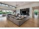 Open living room with a large sectional couch, a modern fireplace, and sliding glass doors to the backyard at 9148 N 66Th Pl, Paradise Valley, AZ 85253