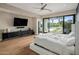 A bright main bedroom suite with hardwood floors, sliding glass door to the backyard pool, and a ceiling fan at 9148 N 66Th Pl, Paradise Valley, AZ 85253