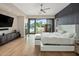 Bright main bedroom with hardwood floors, a king-size bed, and sliding glass doors to the backyard and pool at 9148 N 66Th Pl, Paradise Valley, AZ 85253