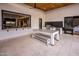 This covered outdoor kitchen features stone floors, a built-in grill, and a serving window to the home's gourmet kitchen at 9148 N 66Th Pl, Paradise Valley, AZ 85253