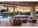 An outdoor living area overlooks the pool and lush backyard landscape, complete with a basketball court at 9148 N 66Th Pl, Paradise Valley, AZ 85253