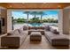 Spacious outdoor patio with sectional sofa overlooking a pool, palm trees, and landscaped backyard at 9148 N 66Th Pl, Paradise Valley, AZ 85253